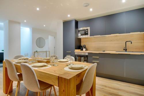 a dining room table with chairs and a kitchen at Welcome to Forest House in Marly-le-Roi