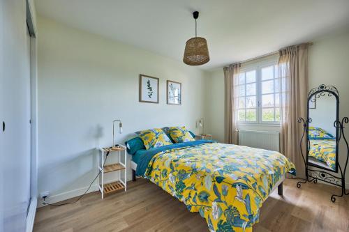 a bedroom with a bed with a colorful comforter and a window at La Valette - A 5 min à pied de la plage in Graye-sur-Mer