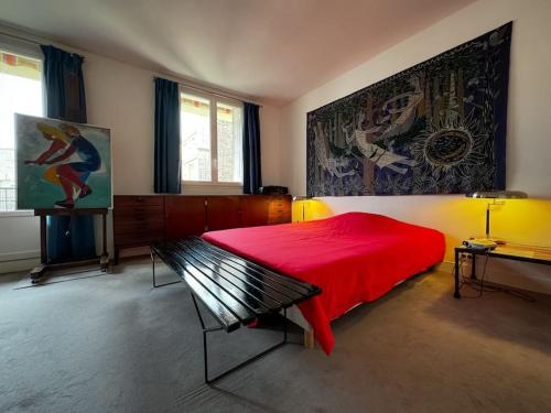 a bedroom with a red bed and a painting on the wall at Bel appartement J.O. 2024 proche sites olympiques in Boulogne-Billancourt