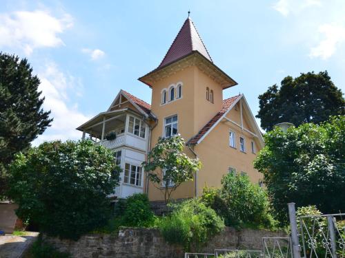 ein großes gelbes Gebäude mit einem Turm oben in der Unterkunft Modern apartment in a listed villa with beautiful view from balcony in Bad Suderode