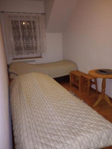 2 camas en una habitación con mesa y ventana en Maja en Szydłów
