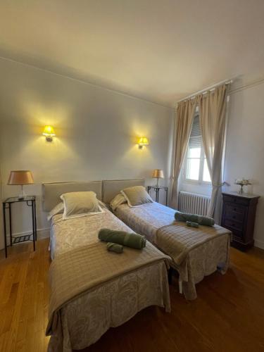 een slaapkamer met 2 bedden en een raam bij B&B rue Royale Versailles in Versailles