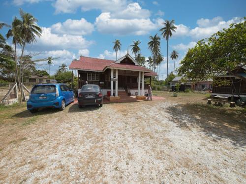 カンポン・ゴン・バダックにあるHotel O Teratak Samuderakita, Chalet & Guesthouseの家の前に駐車された青い車