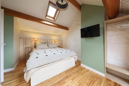 1 dormitorio con 1 cama grande y TV de pantalla plana en L'ESTAMPE, en Auvers-sur-Oise