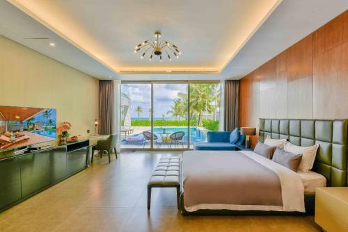 a bedroom with a large bed and a large window at Memories Holiday beach villa Da Nang in Danang