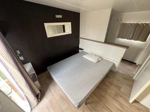 um pequeno quarto com um banco num quarto em MobilHome Comfort XL (37m2) : 2 Chambres (6 personnes) - 2 SDB - Clim centralisée - TV - Terrasse balcon em Cadenet
