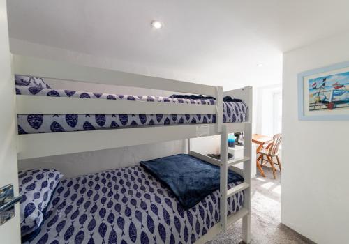 a bedroom with two bunk beds in a room at Inviting Traditional Fishermens cottage in the heart of the village, close to the harbour in Mevagissey
