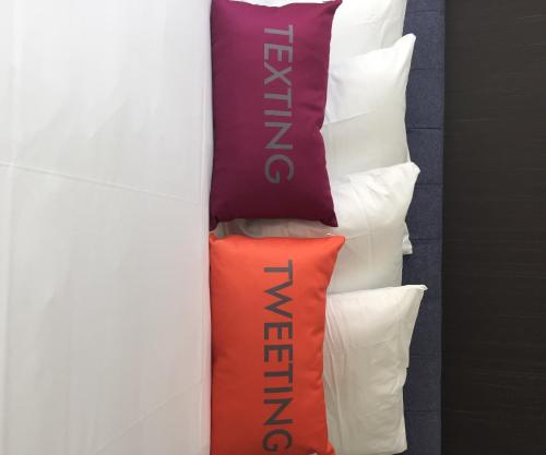 a group of pillows on a bed with a wall at Hotel Lucent in Menlo Park