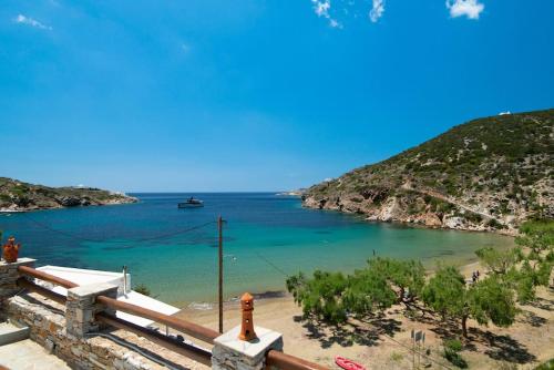 a view of a beach with a boat in the water at Ammos 2 - Seafront maisonette, Glyfo beach, Sifnos in Chrisopigi