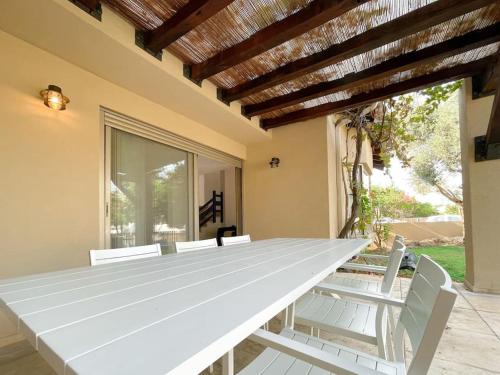 una gran mesa blanca en una habitación con sillas en Stylish Villa with Bomb Shelter Close to Shore, en Cesarea