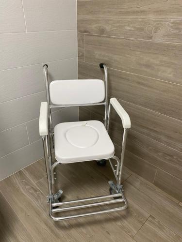 a white chair sitting in a corner of a room at Apartamentos TARELA Porriño in Porriño