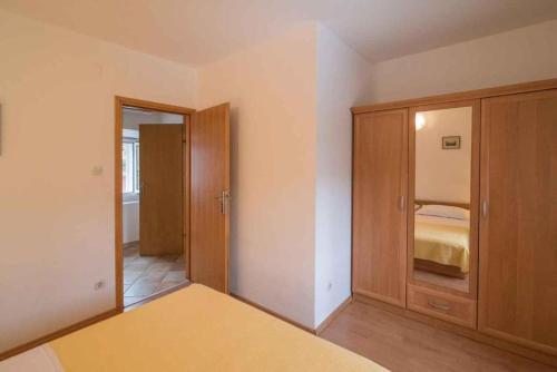 a bedroom with a bed and a wooden cabinet at Greta in Vrbnik