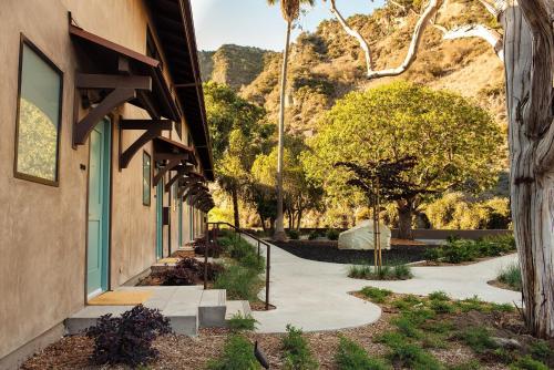 a building with a sidewalk next to a mountain at The Ranch at Laguna Beach in Laguna Beach