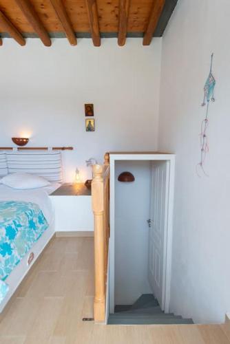 a bedroom with a bed and a door in it at Ammos 2 - Seafront maisonette, Glyfo beach, Sifnos in Chrisopigi