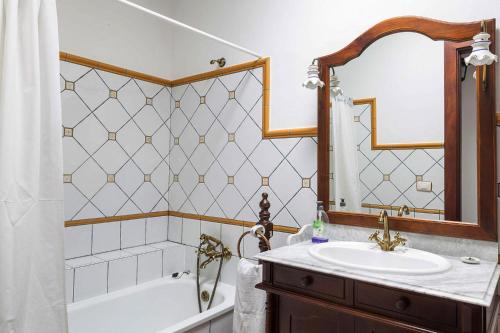 W łazience znajduje się wanna, umywalka i lustro. w obiekcie Holiday Home Puntallana - SPC02018-F w mieście Puntallana