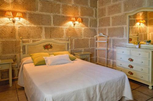 una camera con un letto bianco e un muro in pietra di Holiday home in Malpais de Candelaria with a terrace a Bence