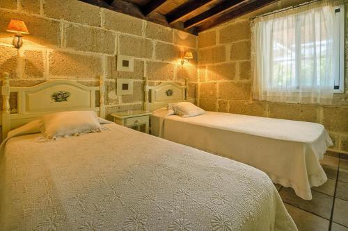 una camera con due letti in una parete in pietra di Holiday home in Malpais de Candelaria with a terrace a Bence
