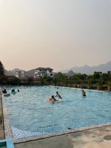 a group of people swimming in a swimming pool at Mộc Homestay in Mộc Châu