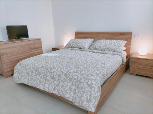 a bedroom with a large bed and a television at FaCentro - Pratico flat in centro storico in Faenza