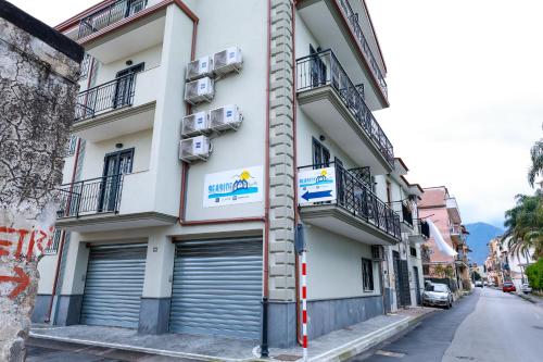 um edifício branco com duas portas de garagem numa rua em Seaside Ruins em Santa Maria La Carità