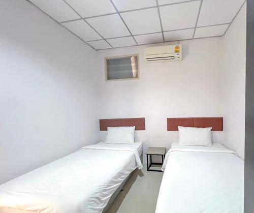 two beds in a room with white walls at The Room Relax in Ban Chang