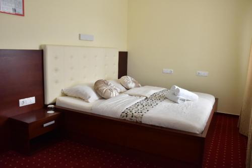 1 dormitorio con 1 cama con sábanas y almohadas blancas en Gostišče Zvezda Ljutomer, en Ljutomer