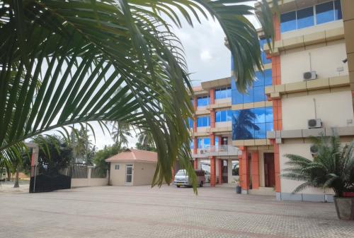 a palm tree in front of a building at Nemart's Hotel in Dar es Salaam