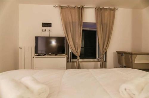um quarto com uma cama e uma televisão de ecrã plano em La casa di anna em Nápoles