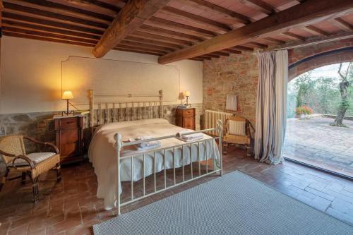 a bedroom with a bed and a stone wall at Villa Bellavista - Homelike Villas in Cavriglia