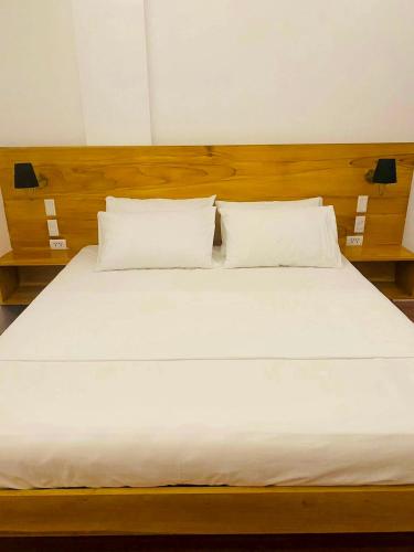a large bed with white sheets and pillows at Minnie's Guest House in Taytay