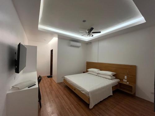 um quarto com uma cama e uma ventoinha de tecto em Minnie's Guest House em Taytay