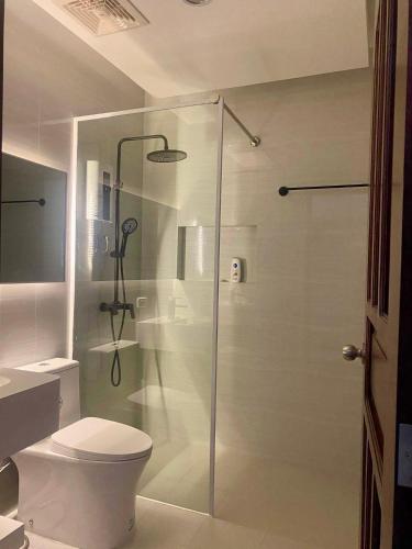 a bathroom with a glass shower with a toilet at Minnie's Guest House in Taytay