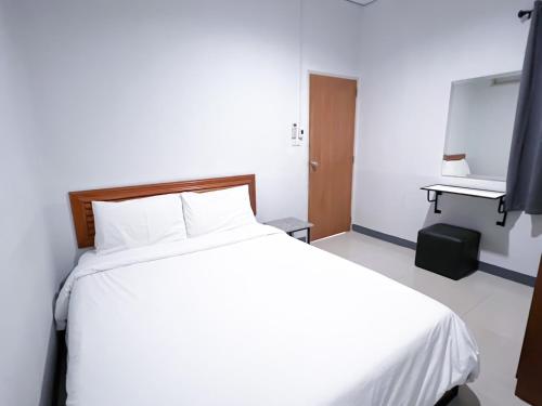 a bedroom with a large white bed and a desk at The Room Relax in Ban Chang