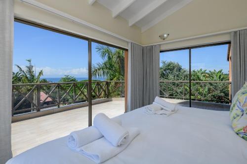 a bedroom with a large bed and large windows at San Lameer Villa - 14014 - 5 Bedroom Luxury - 10 pax - San Lameer Rental Agency in Southbroom