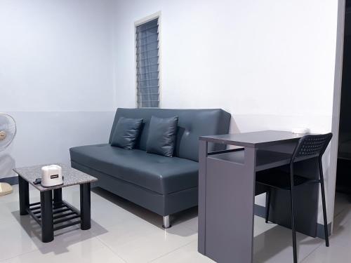 a blue couch and a table in a room at The Room Relax in Ban Chang