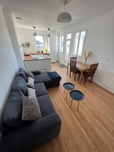 un salon avec un canapé noir et une table dans l'établissement Appartement Hyper-centre proche plage et marché, au Pouliguen