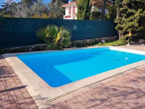 une piscine bleue dans une cour avec une clôture dans l'établissement Appartement confortable à Nice, 25 m² avec piscine partagée, à Nice