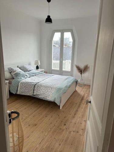 une chambre blanche avec un lit et une fenêtre dans l'établissement Appartement Hyper-centre proche plage et marché, au Pouliguen