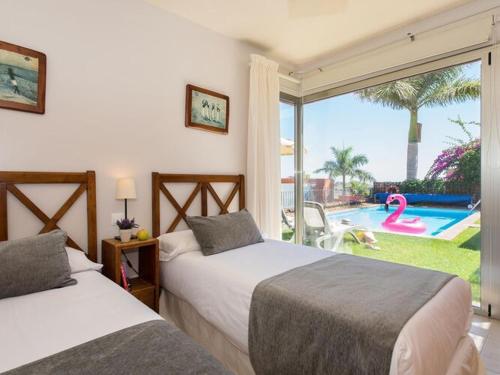 a bedroom with two beds and a pool and a window at Holiday Home Maspalomas - LPA03100h-O in Maspalomas