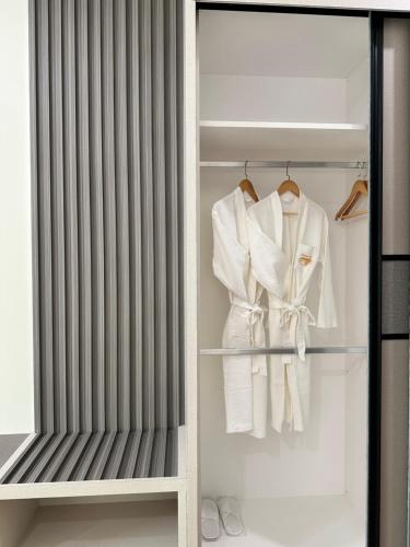 a wardrobe with white clothes and a curtain at Wendu Inn Hotel in Kota Belud