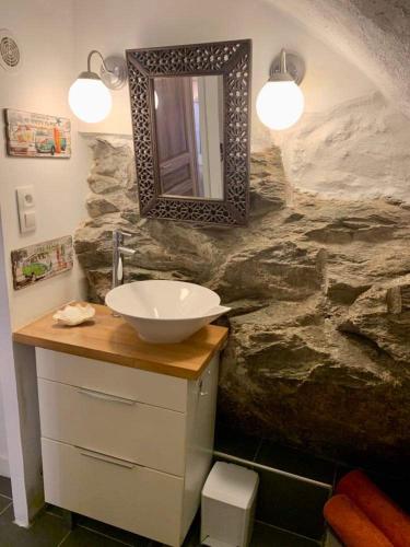 une salle de bain avec un lavabo et un mur en pierre dans l'établissement La Corse authentique et rurale, à Castifao