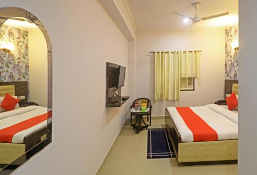 a hotel room with two beds and a mirror at Hotel Samara Kingdom Near Delhi Airport in New Delhi