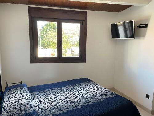 a bedroom with a bed and a tv on the wall at Casa Divarro in O Grove