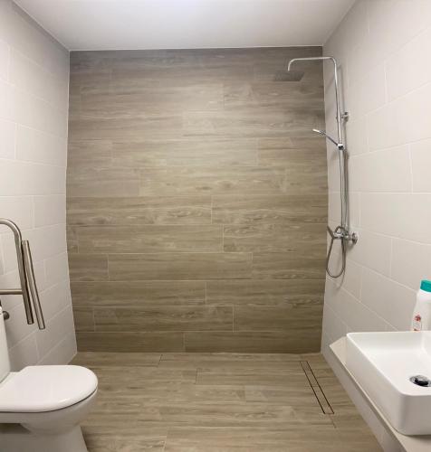 a bathroom with a shower and a toilet and a sink at Apartamentos TARELA Porriño in Porriño