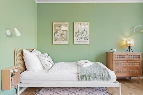 a bedroom with green walls and a white bed at NEUE moderne Apartments nahe Uni, zentral in Cottbus