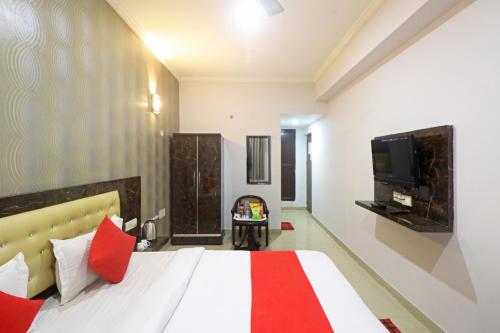 Hotel Samara Kingdom Near Delhi Airport في نيودلهي: غرفة فندق بسرير وتلفزيون