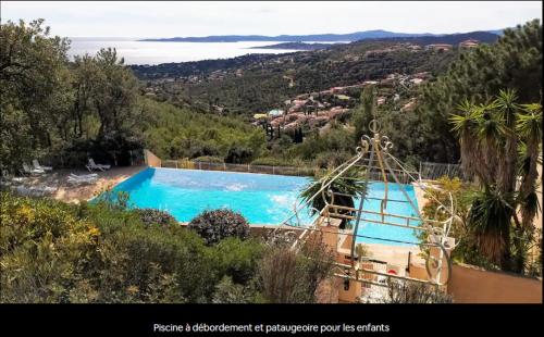 Elle offre une vue sur une grande piscine bleue bordée d'arbres. dans l'établissement joli 2 pieces vue mer , piscine proche ste Maxime résidence BELLEVUE, à Roquebrune-sur Argens
