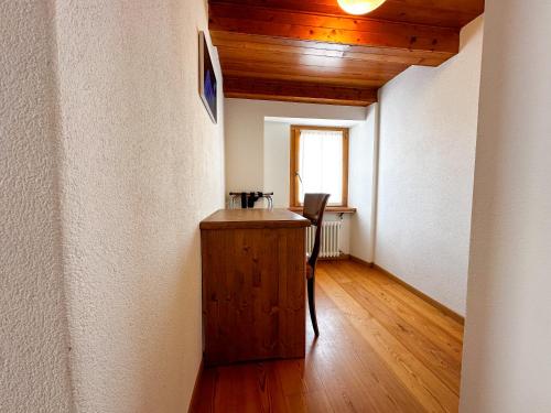 a hallway with a table and a chair in a room at Locanda Orelli in Bedretto