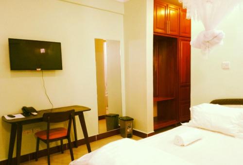 a hotel room with a desk and a bed at Nemart's Hotel in Dar es Salaam