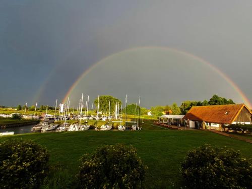 un arco iris en el cielo sobre un puerto deportivo con barcos en Pensjonat Żurawi Kąt, en Górkło